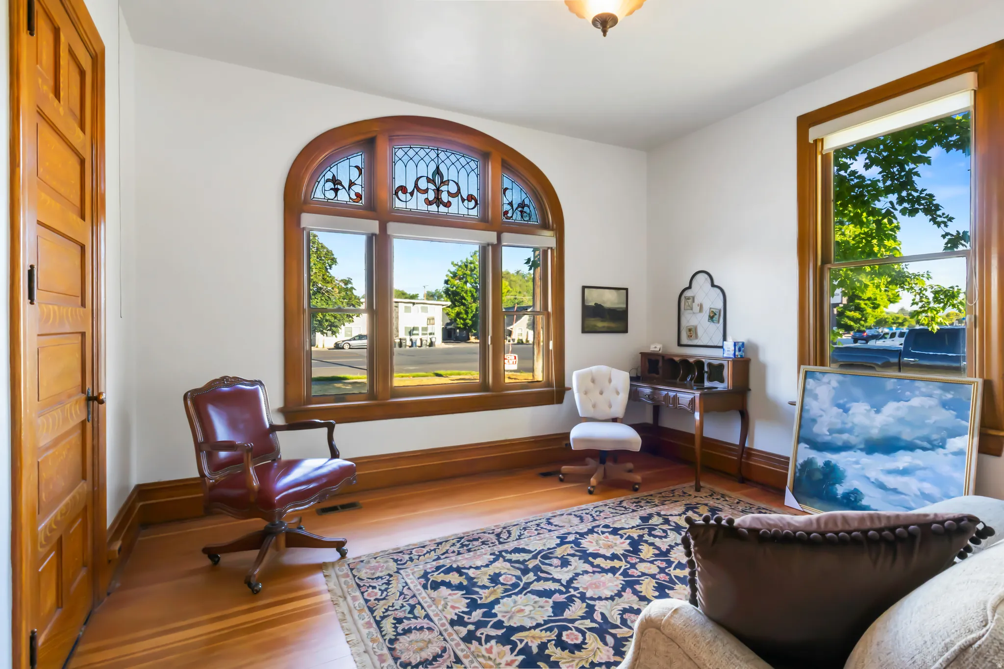 Hardwood flooring throughout featuring a decorative area rug