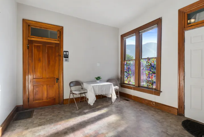 Interior space featuring multiple windows with mountain scenery, a paneled wood door with transom, and wood trim detailing throughout