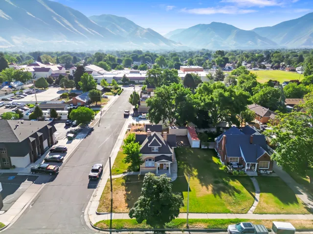 Residential neighborhood featuring a mix of architectural styles, mature trees, and a mountain backdrop