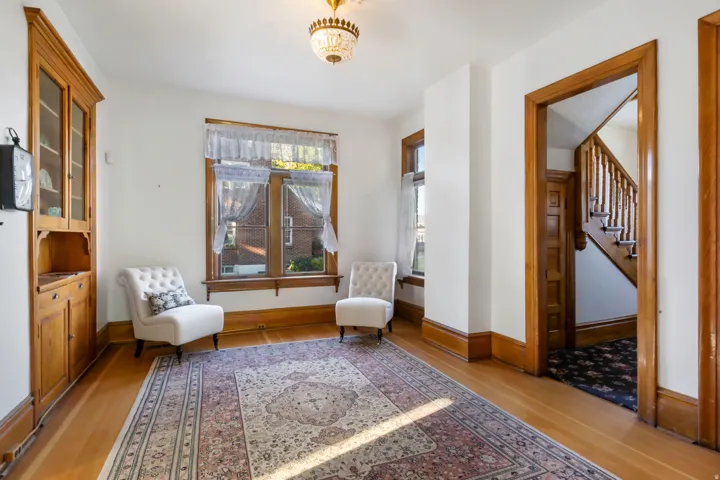 Hardwood flooring extending throughout, complemented by a built-in wooden hutch with glass-fronted upper cabinets and lower storage