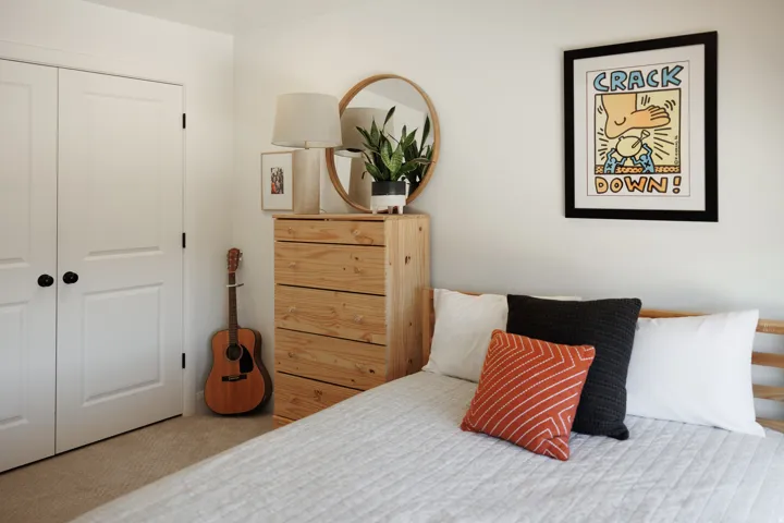Light-toned wood-finish bed frame with a white quilted spread