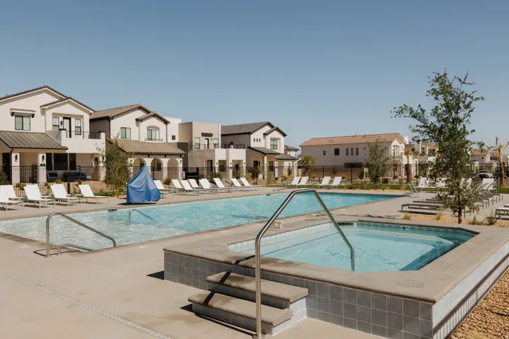 Resident Community swimming pool with an integrated spa, surrounded by a concrete deck and multiple lounge chairs