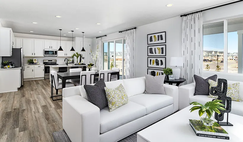Bright living area with wood-finish flooring, white cabinetry, recessed lighting, and a sliding glass door