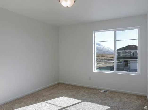 Neutral-toned carpeting, white walls, and a fixed window