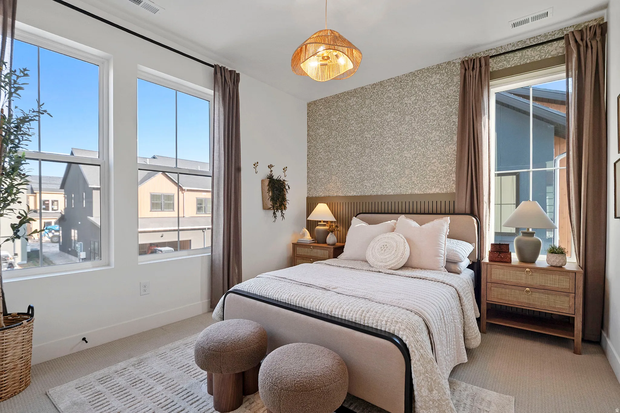 Bedroom featuring a decorative accent wall with paneling and patterned wallpaper