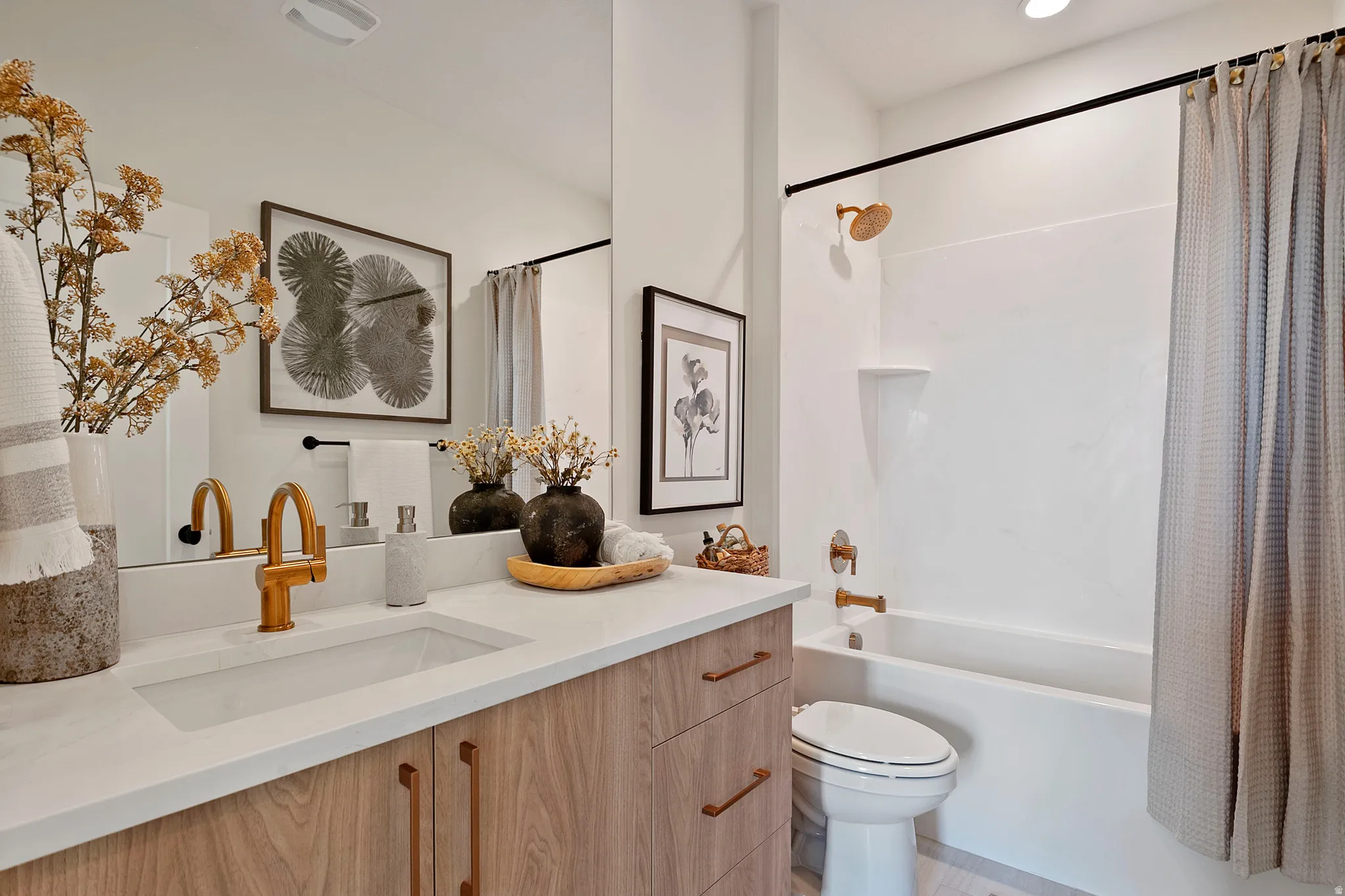 Contemporary bathroom featuring a wood-finish vanity with a white countertop and integrated sink