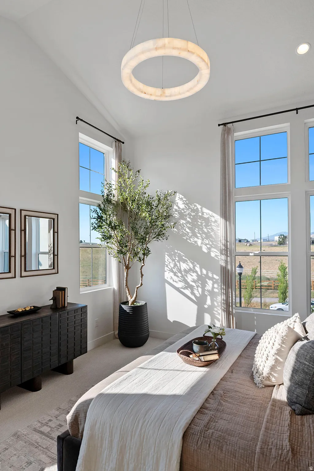 Room featuring high vaulted ceilings, a large circular chandelier, and extensive fenestration with multi-pane windows