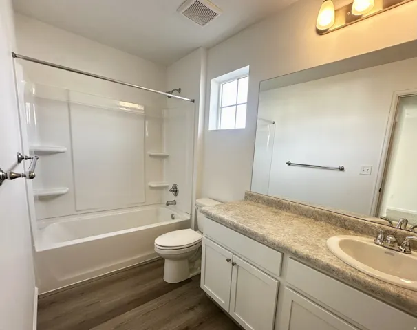 White cabinet vanity with an integrated sink and light-toned countertop