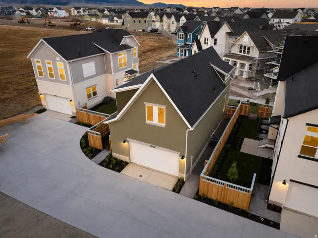 Contemporary two-story residence featuring a dark asphalt shingle roof and light olive green siding