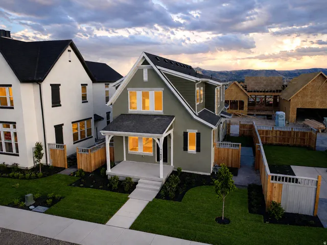 Contemporary-style residence featuring a covered front porch, dark siding, white trim, and black shutters