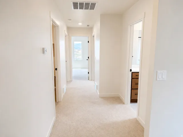 Carpeted hallway featuring recessed lighting and white trimwork