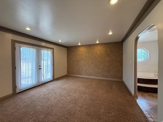 Spacious room featuring broadloom carpeting, recessed lighting, and a textured accent wall