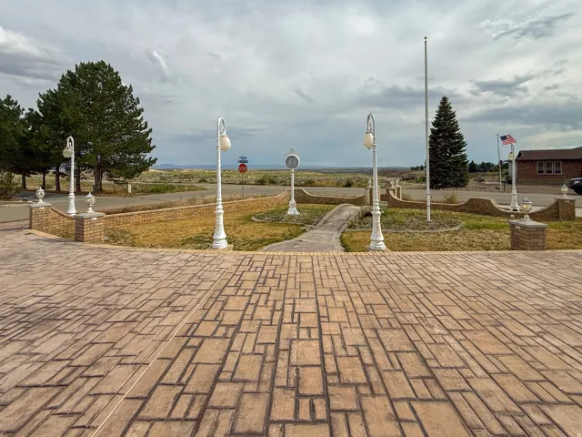 Stamped concrete patio with a decorative brick border and white lampposts