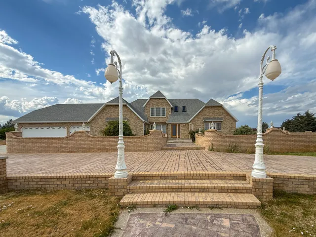 Brick exterior residence featuring a multi-gabled roofline and attached two-car garage