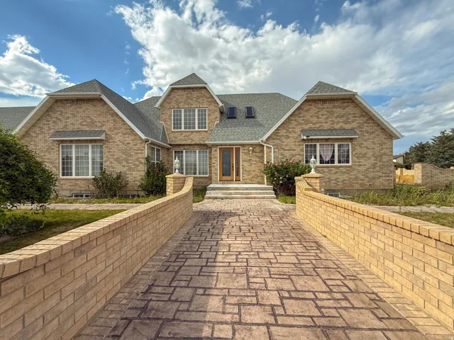 Brick exterior residence featuring multiple gables and a gray shingled roof