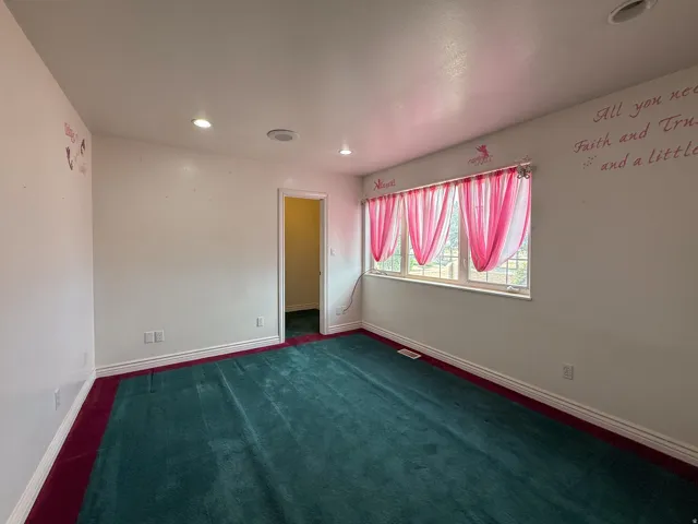 Carpeted room with white walls, recessed lighting, and white baseboards