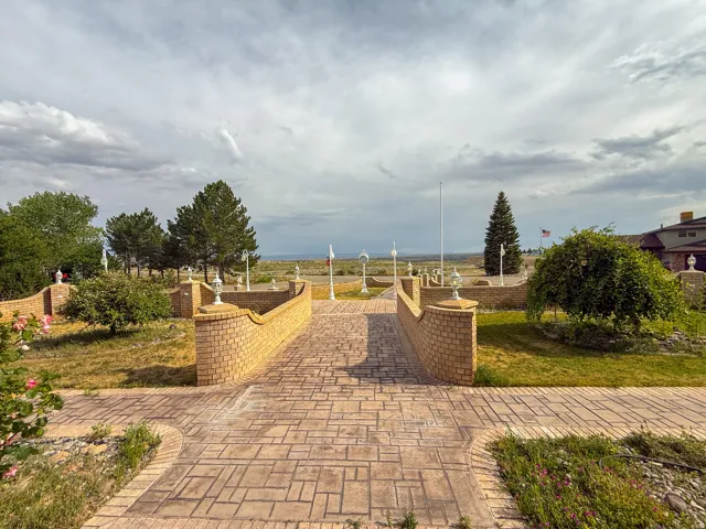 Expansive outdoor area featuring a patterned paver pathway and matching brick retaining walls