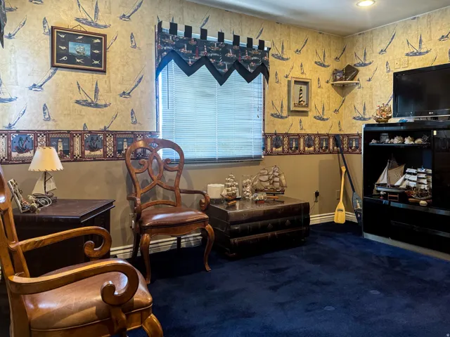 Room featuring dark blue carpeting and a window with blinds