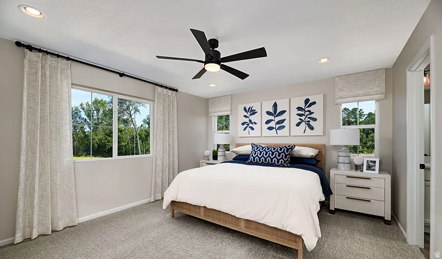 Carpeted room featuring multiple windows with tree-lined scenery