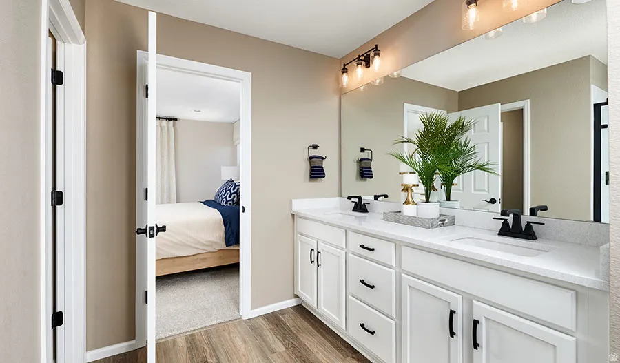 Spacious bathroom featuring a dual vanity with white cabinetry and black hardware
