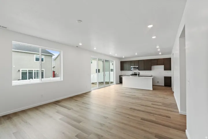 Open concept living space with recessed lighting and light wood-finish flooring