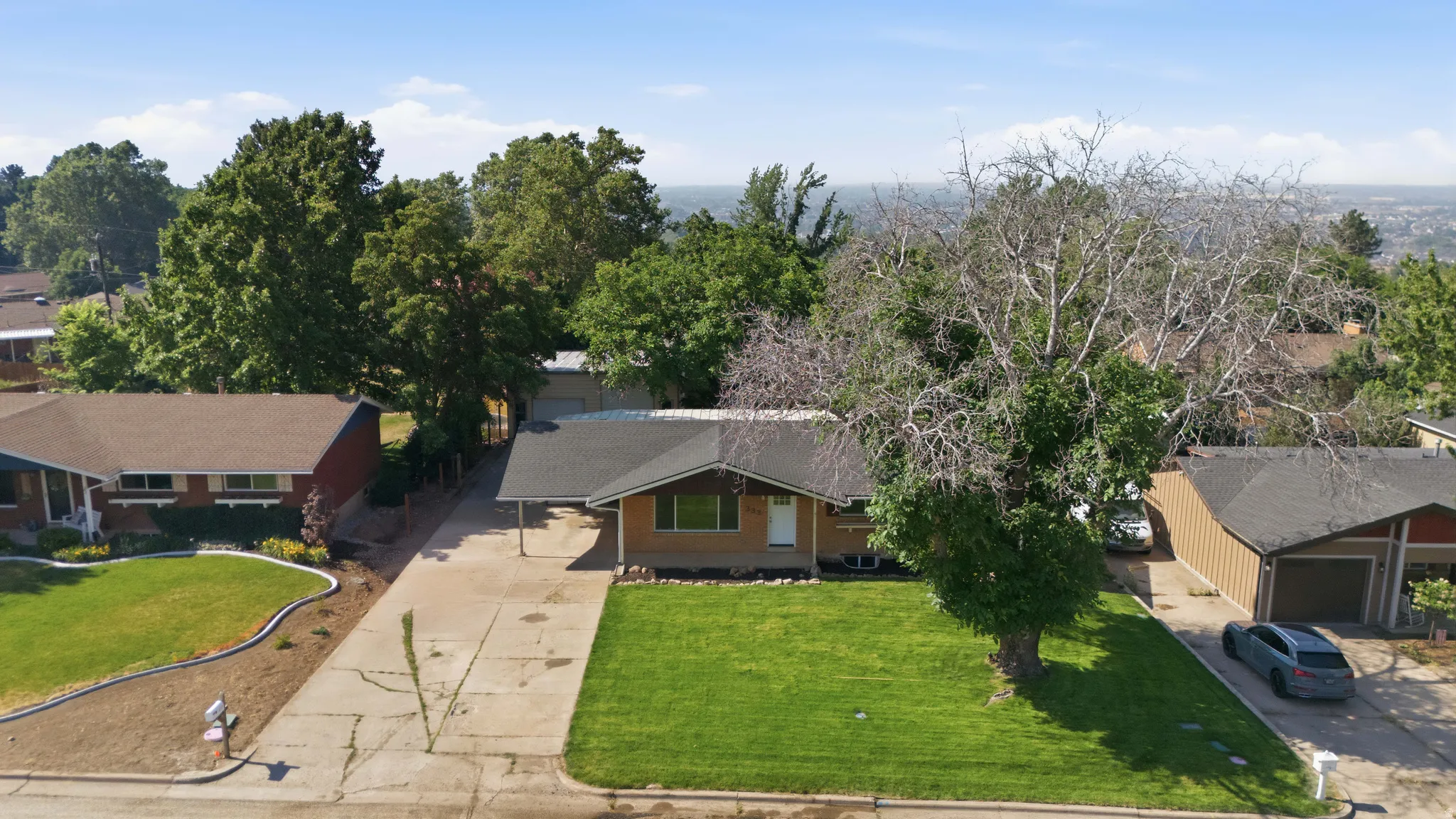 Ranch-style residence featuring a brick facade and a covered carport