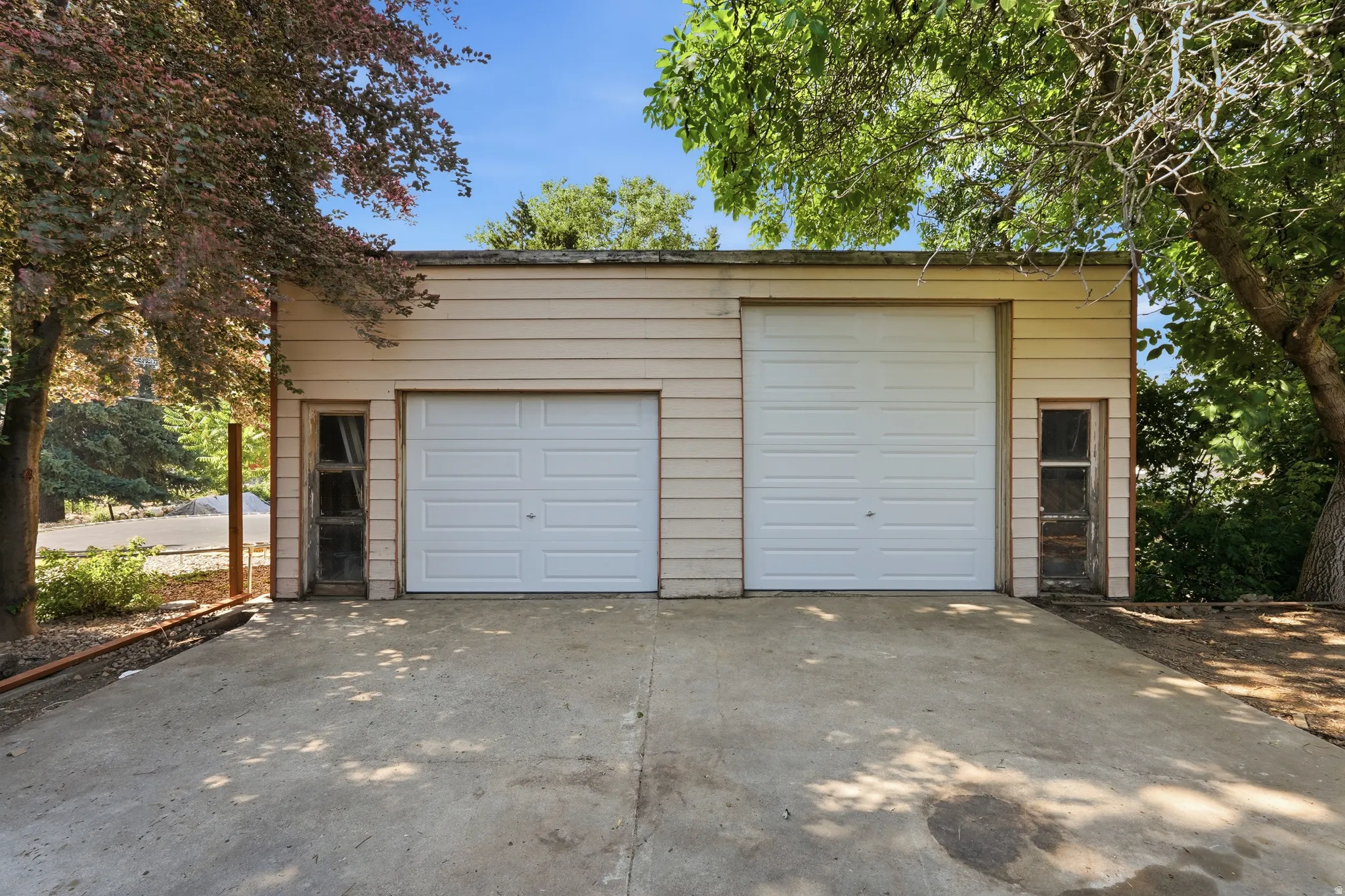 Two-car detached garage with horizontal siding and concrete driveway apron