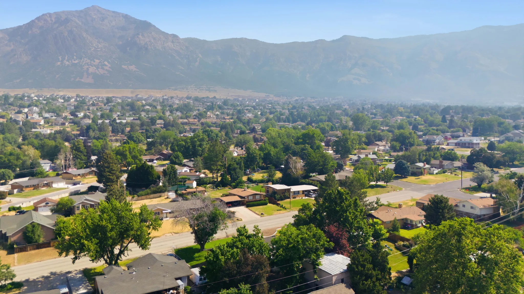 Expansive residential area featuring established homes, mature landscaping, and mountain backdrops