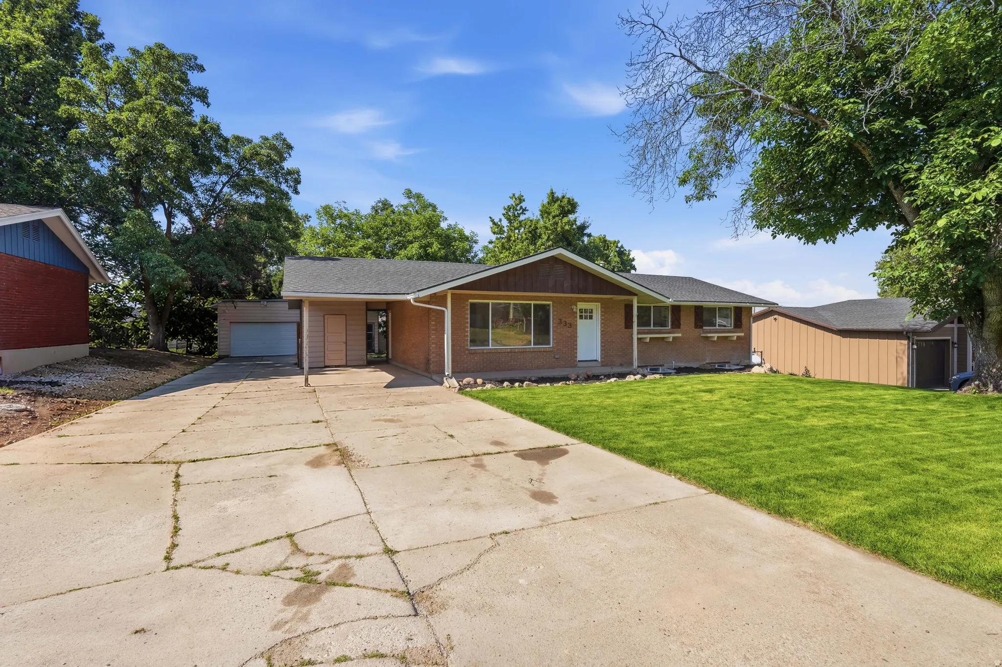 Ranch-style residence featuring a brick facade, covered entry, and a single-car garage