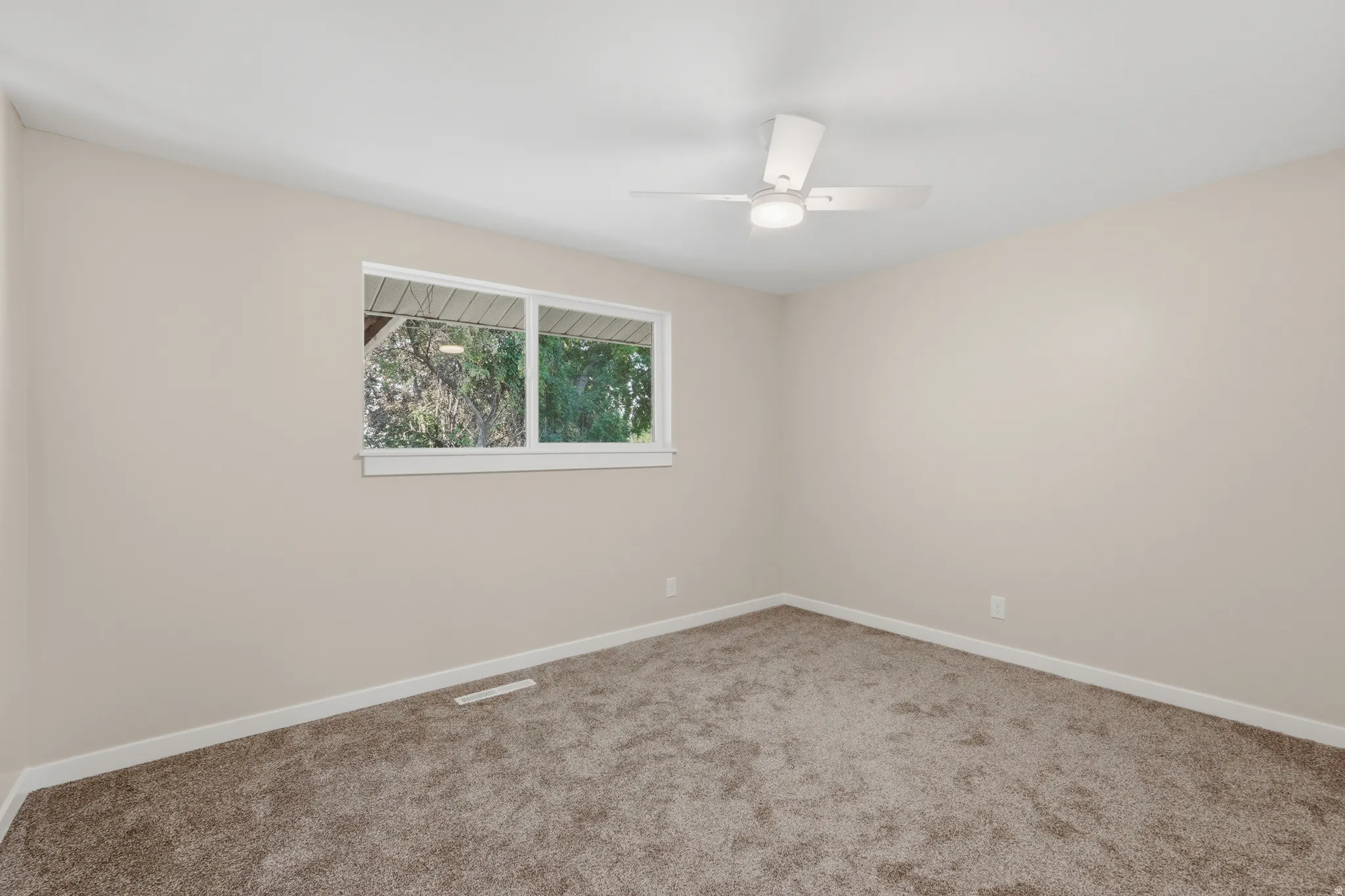 Neutral-toned walls and plush carpeting complement the white trim