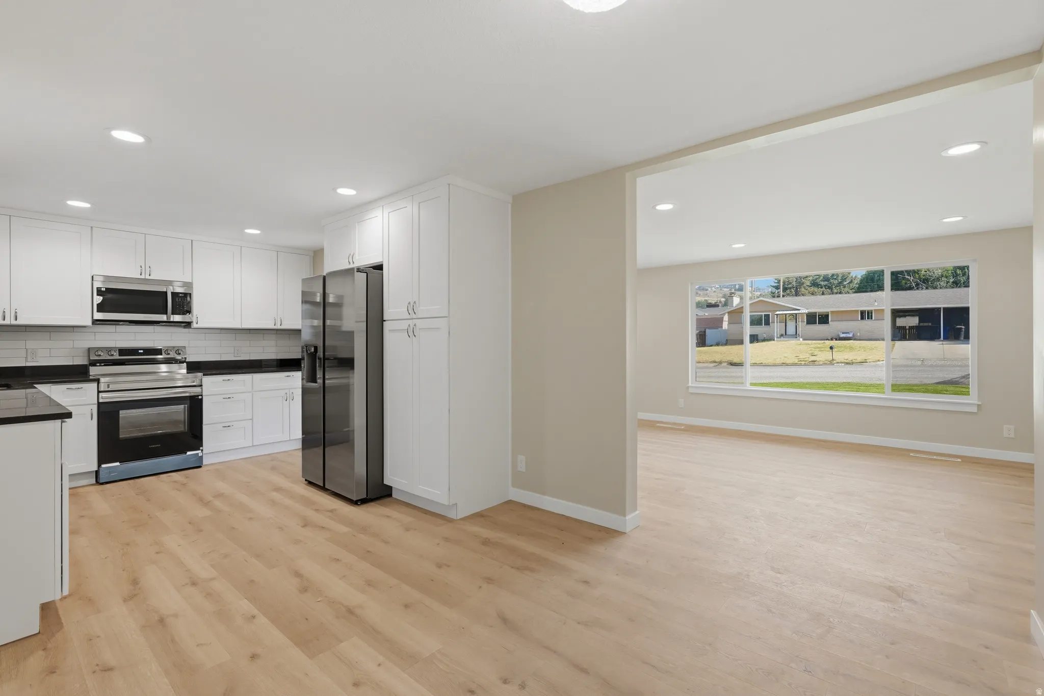 Kitchen and living area featuring light wood-finish flooring