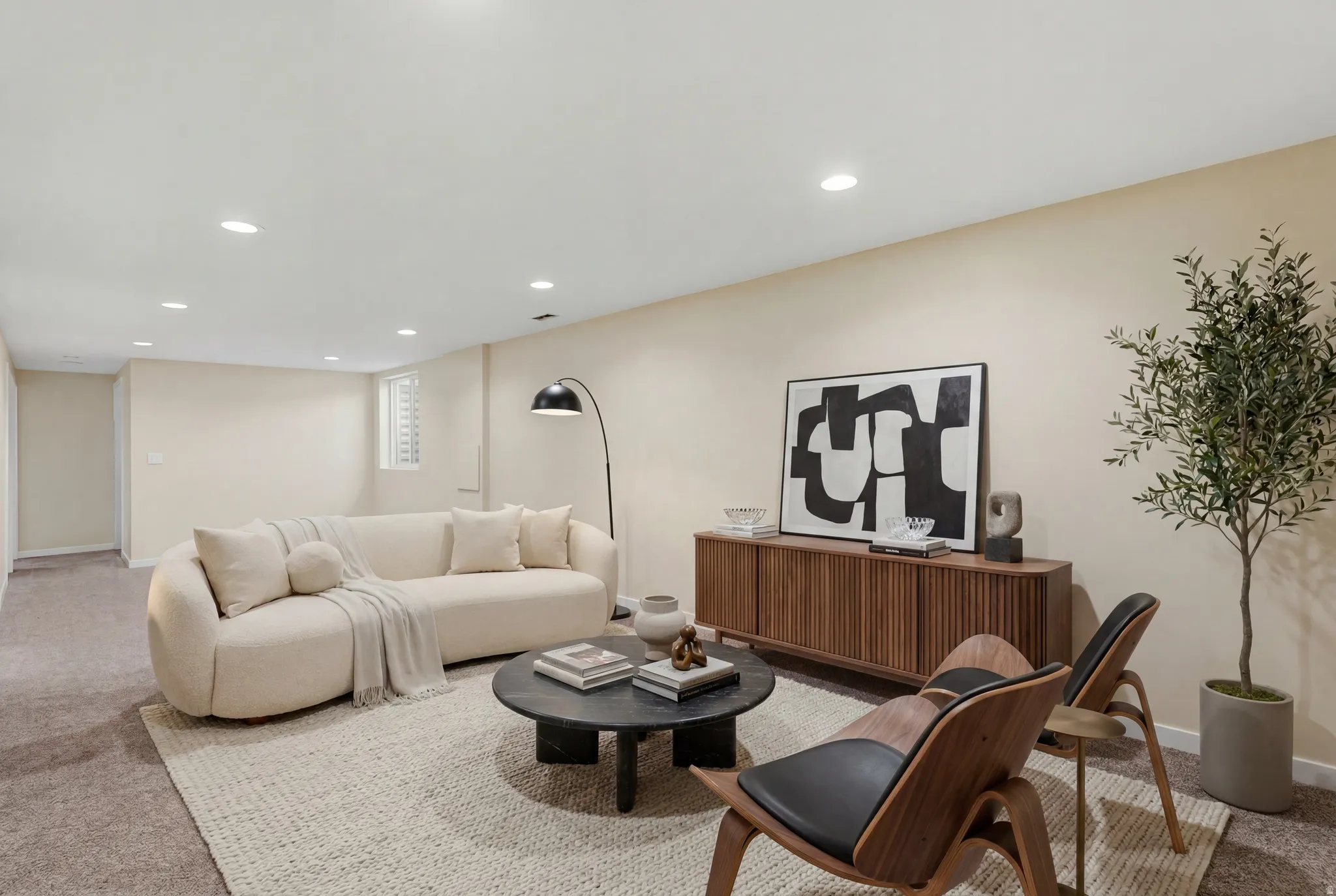 Spacious room featuring neutral wall tones, recessed lighting, and a textured area rug over carpeting. Virtually Staged