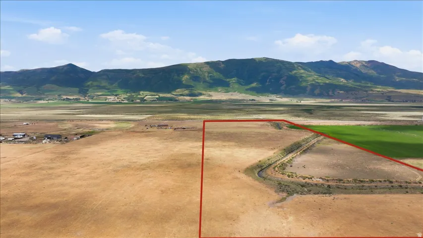 Expansive parcel of land featuring open fields and a natural water channel