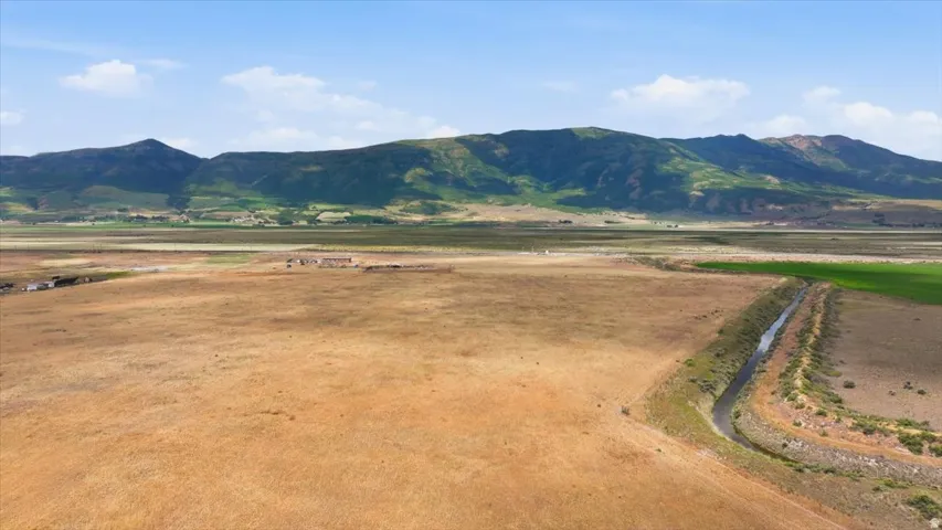 Expansive rural acreage featuring a natural water channel and distant mountain range
