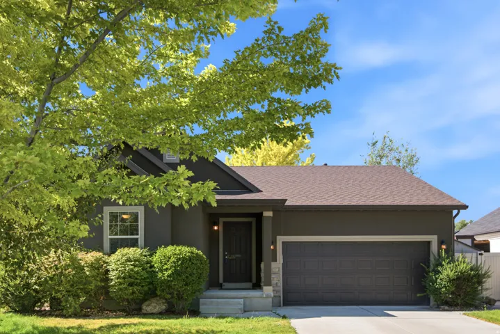 Contemporary exterior with a dark gray facade, an attached two-car garage, a covered entry, and a light brown shingle roof