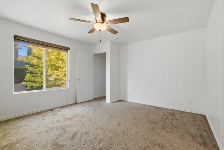 Room with neutral carpet flooring, white walls, and a multi-pane window