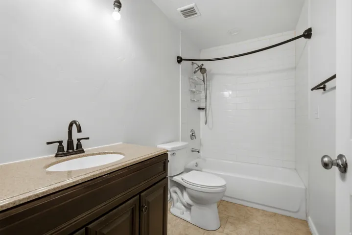 Bathroom featuring a vanity with an integrated sink, a dark bronze faucet, and a light-toned countertop