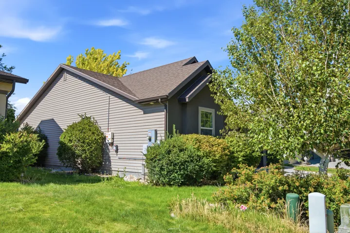 Exterior featuring horizontal siding, a gabled roofline, and established landscaping
