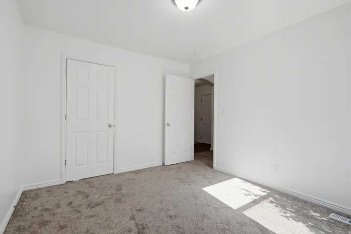 Bedroom with neutral-toned carpet flooring and white walls