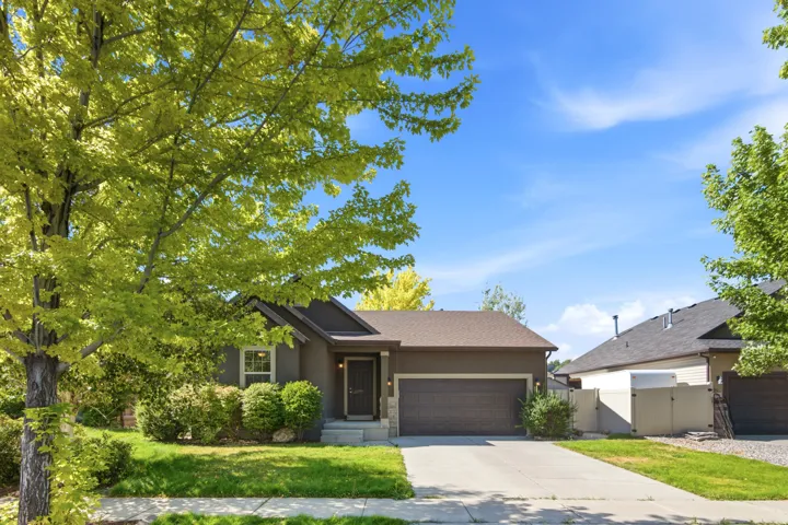 Single-story residence featuring a brown exterior, an attached garage with a dark brown door, and a gray shingle roof