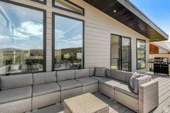 Spacious outdoor deck featuring composite decking and a modern slatted siding exterior