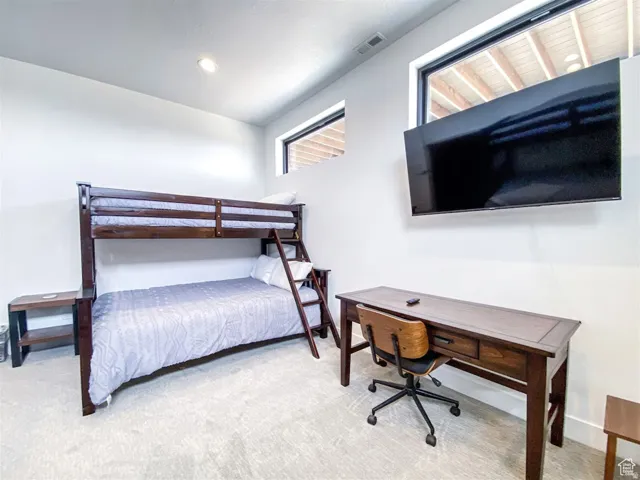 Room featuring light-toned carpeting, recessed ceiling lighting, and upper windows