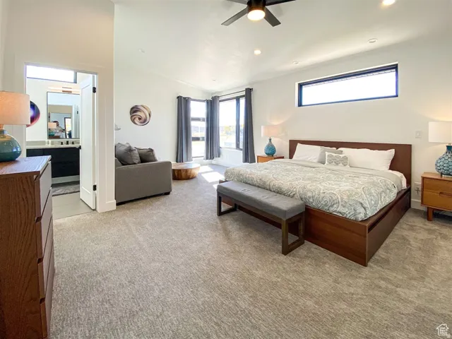 Spacious bedroom featuring vaulted ceilings, recessed lighting, a ceiling fan, and large windows with privacy blinds