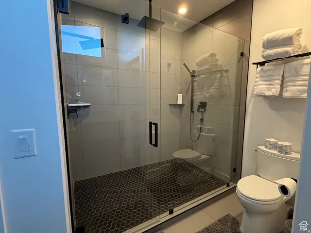 Contemporary walk-in shower with clear glass enclosure and black hexagonal tile flooring