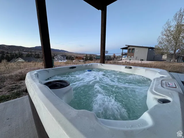 Outdoor spa featuring bubbling water, integrated controls, and a neutral-toned shell