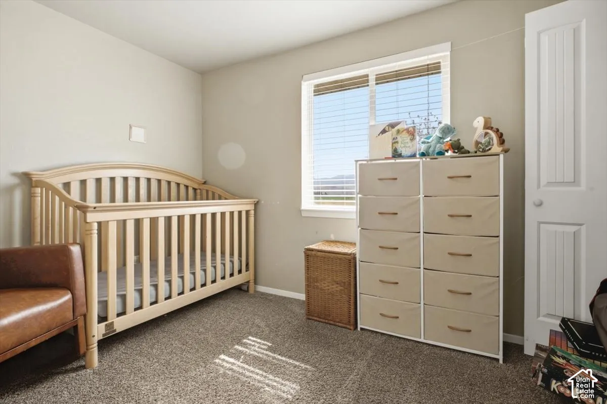 Neutral-toned room featuring a large window with horizontal blinds, providing ample natural light
