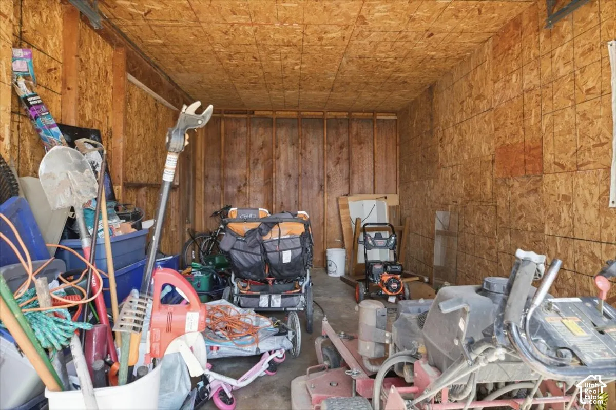 Utility shed interior featuring OSB walls and ceiling, exposed wood framing, and a concrete floor