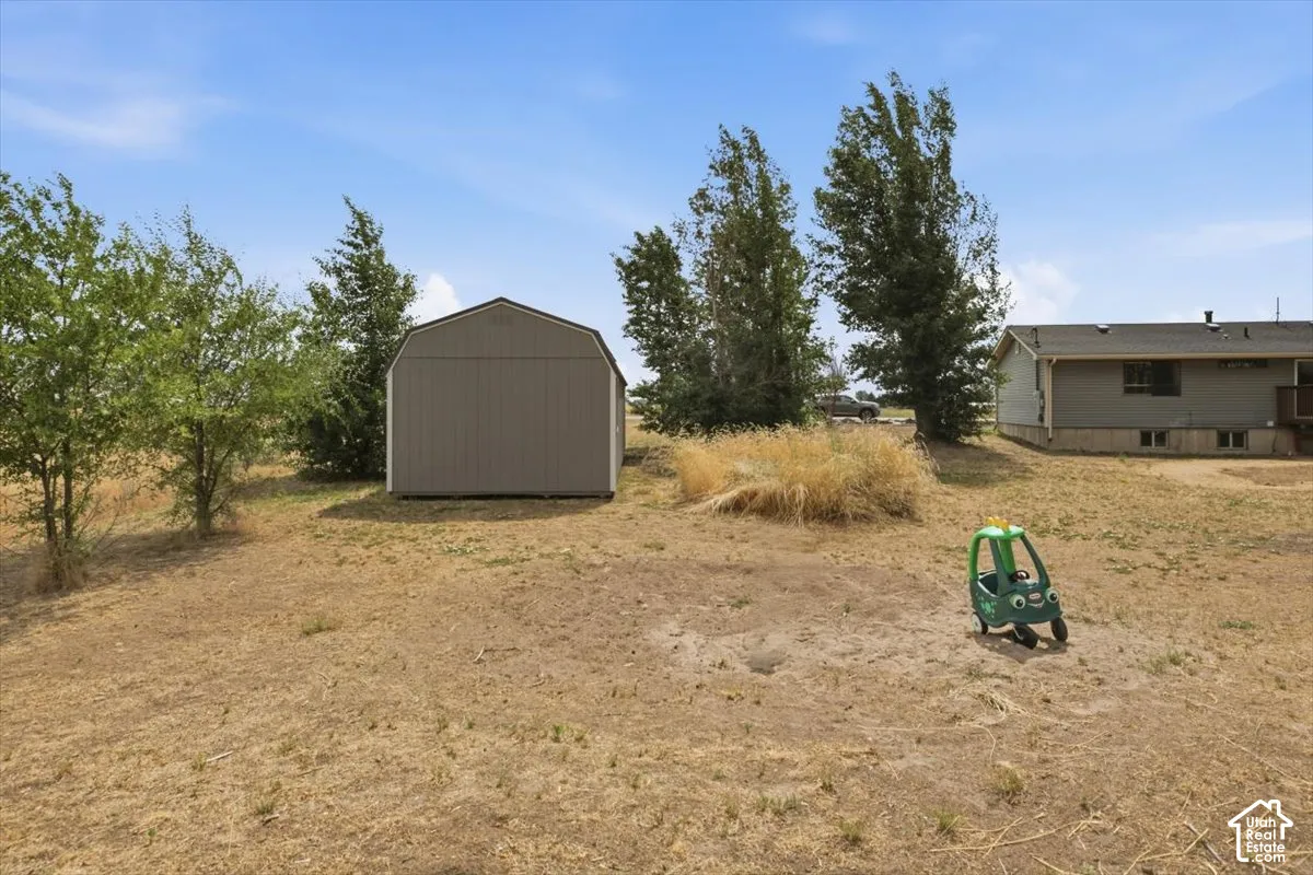 Detached shed with gambrel roof and gray siding