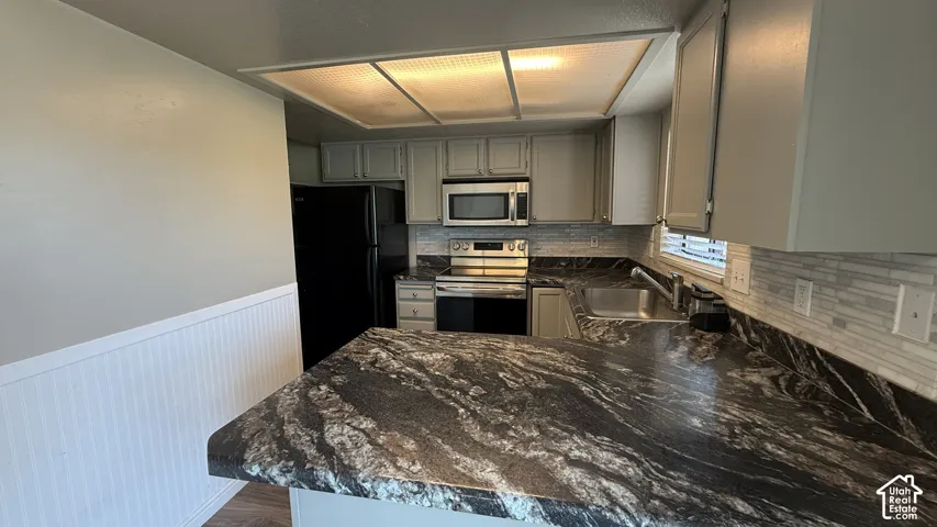 Kitchen with patterned countertop, stainless steel sink, tiled backsplash, and recessed lighting