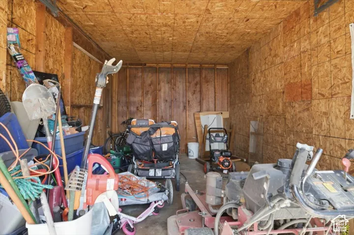 Utility shed interior featuring OSB walls and ceiling, exposed wood framing, and a concrete floor